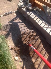 Using a rake to spread crusher fine base for flagstone patio.