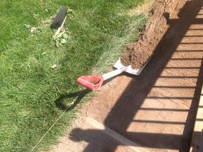 Shoveling out excess crusher fine base for flagstone patio.